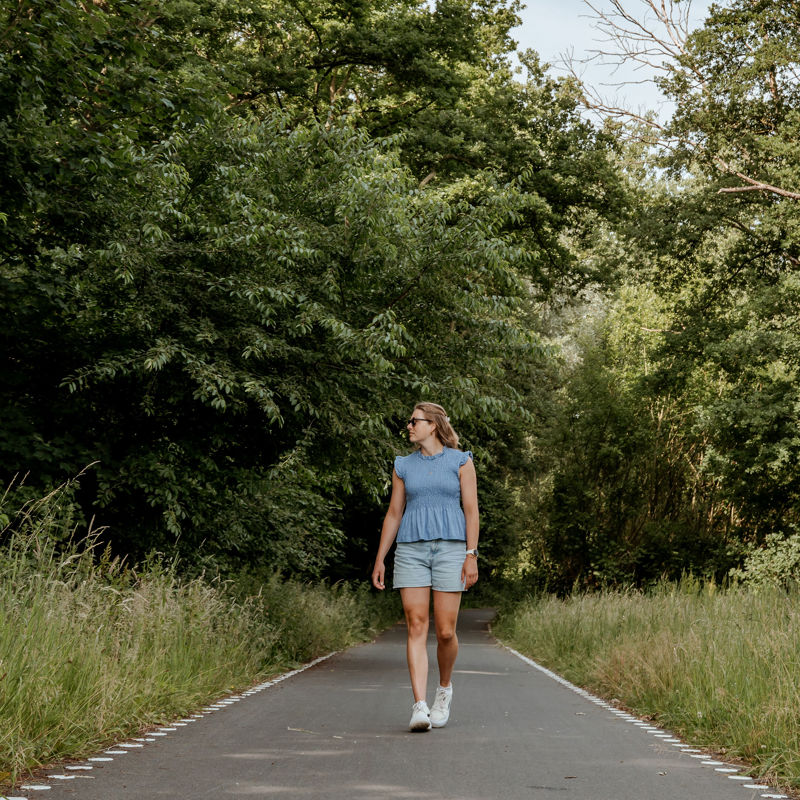 Vrouw wandelt over de Parkstadroute in een groene omgeving. 