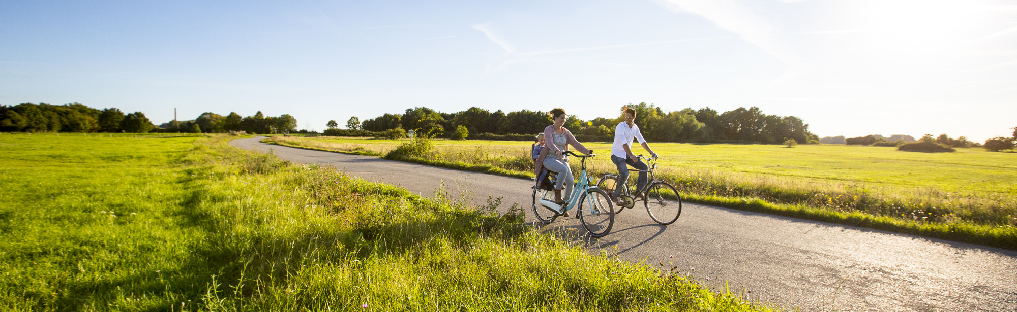 Moeder met kind achterop en vader fietsen door Zuid-Limburg