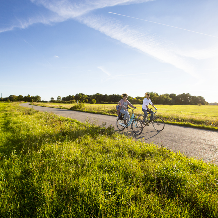 Moeder met kind achterop en vader fietsen door Zuid-Limburg