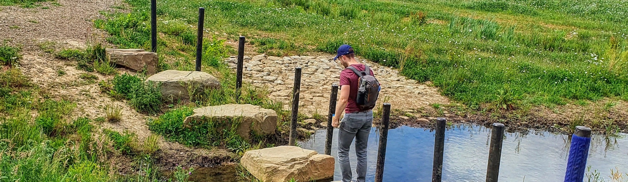 Een man loopt over de stapstenen in Voerendaal