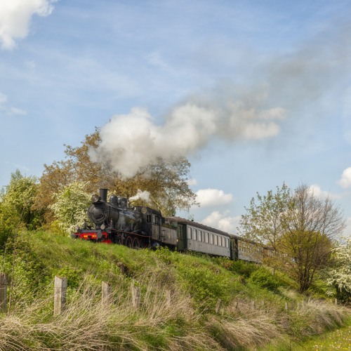 Stoomlocomotief de Miljoenenlijn rijdt door het Zuid-Limburgse landschap