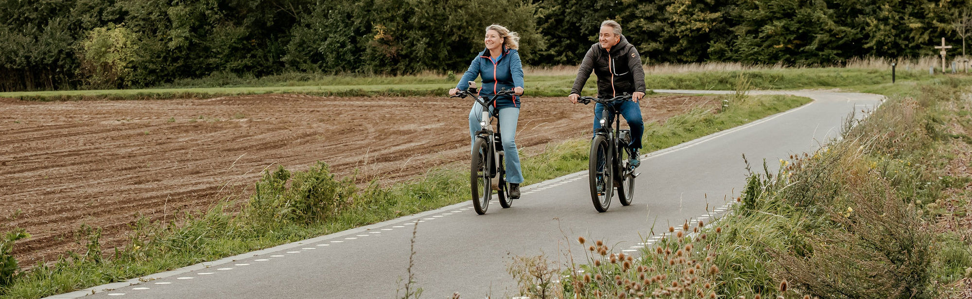 Twee fietsers op de Parkstadroute in Simpelveld, kijken naar het uitzicht.