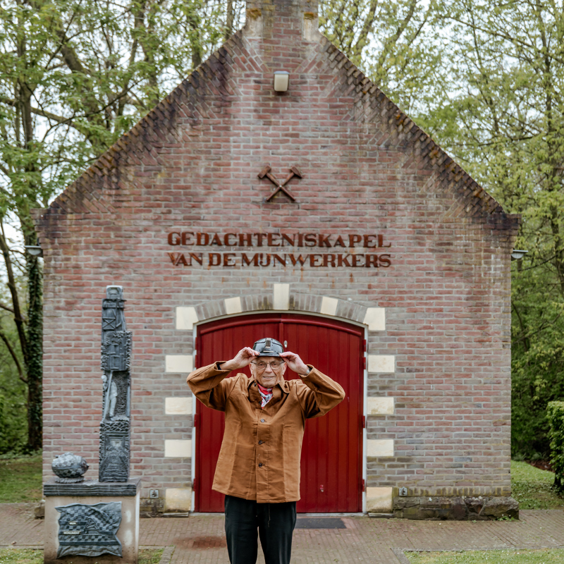 Oud-mijnwerker houdt zijn helm vast voor de gedachteniskapel van de mijnwerkers in landgraaf.