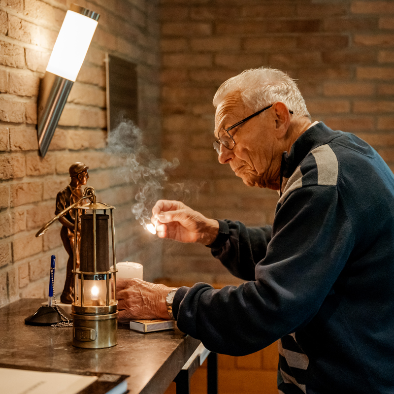Martin steekt een oude olielamp aan in de gedachteniskapel voor de mijnwerkers.